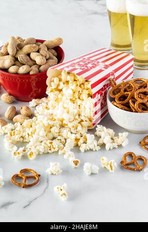 Eine vertikale Ansicht von Snackbehältern mit Biergläsern im Hintergrund. Stockfoto