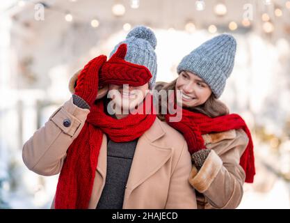 Liebevolle Dame macht Überraschung für Freund, Winter Schuss Stockfoto