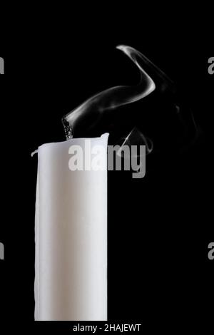Eine Kerze mit Flamme gelöscht, Rauch, auf schwarzem Hintergrund. Nahaufnahme. Stockfoto