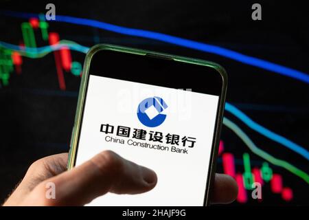 China. 09th Dez 2021. In dieser Abbildung sehen Sie das Logo des chinesischen multinationalen Bankunternehmens China Construction Bank Corporation (CCB), das auf einem Smartphone mit einem Index-Diagramm der wirtschaftlichen Börse im Hintergrund zu sehen ist. (Foto von Budrul Chukrut/SOPA Images/Sipa USA) Quelle: SIPA USA/Alamy Live News Stockfoto