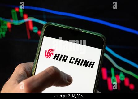 China. 09th Dez 2021. In dieser Abbildung ist das Logo der Fluggesellschaft Air China abgebildet, das auf einem Smartphone mit einem wirtschaftlichen Börsenindex im Hintergrund zu sehen ist. (Foto von Budrul Chukrut/SOPA Images/Sipa USA) Quelle: SIPA USA/Alamy Live News Stockfoto