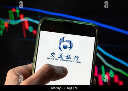 China. 09th Dez 2021. In dieser Abbildung ist das Logo der chinesischen Bank of Communications zu sehen, das auf einem Smartphone mit einem Index der wirtschaftlichen Börse im Hintergrund angezeigt wird. (Foto von Budrul Chukrut/SOPA Images/Sipa USA) Quelle: SIPA USA/Alamy Live News Stockfoto