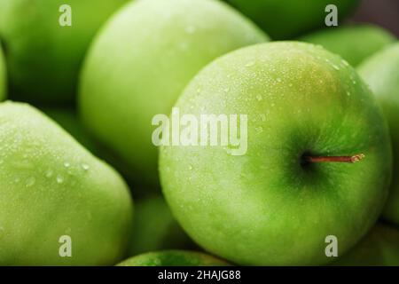 Reife Frucht eines grünen Apfels in Nahaufnahme mit Tautropfen. Saftige Früchte im Vollbildmodus Stockfoto