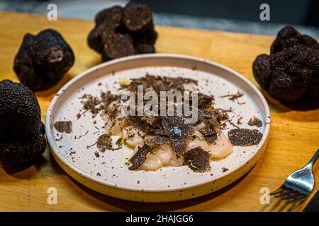 Frische Jakobsmuscheln mit Meersalz, schwarzem Pfeffer und Olivenöl und frisch rasierten schwarzen Trüffeln. Reduziert auf diese wenigen Zutaten, kommt der Geschmack des schwarzen Trüffels sehr gut zum Vorliegen. Aups, Frankreich Stockfoto