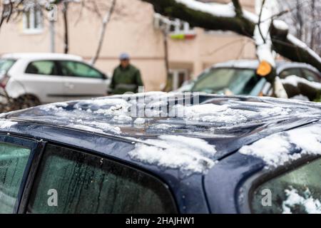 Tall Tree stürzte auf das Auto und zerquetschte es aufgrund eines starken Schneesturms Stockfoto