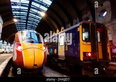 LNER Azuma Express-Intercity-Zug in York Station am Bahnsteig, neben einem lokalen Northern Trains Pendlerzug. London North Eastern Railway. Fast Stockfoto