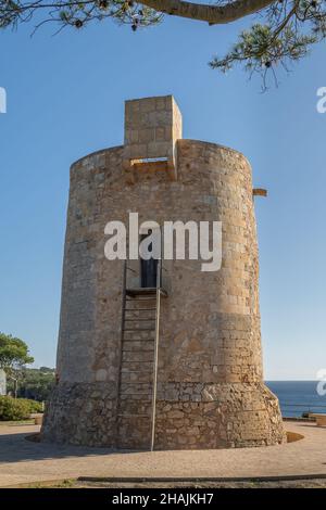 Gesamtansicht des mittelalterlichen Turms Torre Nova im mallorquinischen Ferienort Cala Santanyi, an einem sonnigen Tag mit dem Mittelmeer im Hintergrund Stockfoto