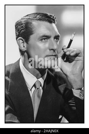 CARY GRANT Vintage Hollywood B&W Studio Portrait 1931 Cary Grant mit Zigarettenhalter und Zigarette CARY GRANT (1904-1986) der in England geborene amerikanische Hollywood Heart Throb-Filmstar Stockfoto
