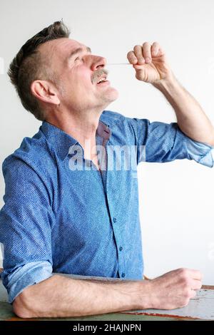 Ein hübscher Mann mit 50s Jahren, der einen Corona-Selbsttest machte Stockfoto