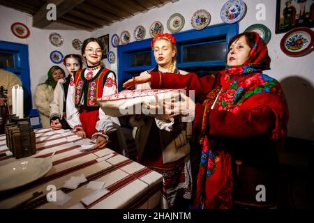 Nicht exklusiv: USCHHOROD, UKRAINE - 10. DEZEMBER 2021 - Menschen in traditionellen ukrainischen Kostümen führen die Rituale während der Andriivski-Vechornyts durch Stockfoto