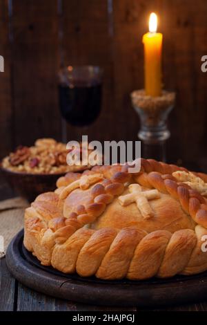 Serbischer slava-Kuchen mit Weizen und Kerze. Slavski kolač. Dekoratives Brot für traditionelle Feste. Stockfoto