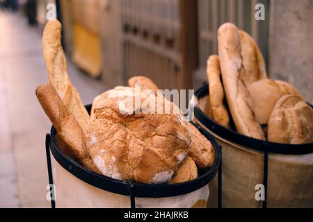 Frisch gebackenes traditionelles Brot in einem Korb auf einer Straße. Abbildung: Feinkostgeschäft Bäckerei. Stockfoto