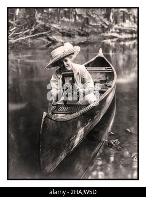 Vintage Lifestyle-Werbung 1900s Frau im Freien im Flusskanu zeigt die neueste KODAK Faltenbälge Rollfilmkamera mit Auslöseautomatik für die Luftbirne. Tragbare Kameras eine fotografische Revolution. Werbefoto zeigt junge Frau, die im Kanu sitzt und auf einen Faltenbalg zeigt Kamera c1909 Kameras--1900-1910 Fotografen--1900-1910 - Fotografie--1900-1910 Frauen--1900-1910 - Kanus--1900-1910 Fotodrucke--1900-1910. Stockfoto