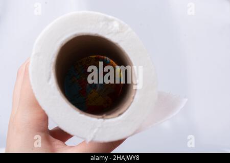 Eine weibliche Hand nimmt eine Rolle weißes Toilettenpapier in die Hand. Stockfoto