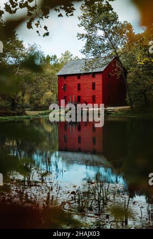 EMINENCE, - 05. Oktober 2020: Eine vertikale Aufnahme des roten Gebäudes am Seeufer. Alley Spring Water Mill in Eminence, Missouri. Stockfoto