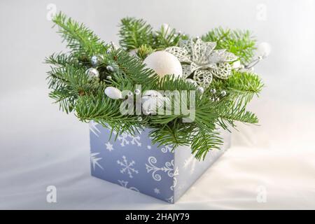 Weihnachtsschmuck zum Neujahr mit Tannenzapfen. Und weißen Kugeln in einer blauen Schachtel Stockfoto