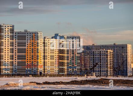 Sankt Petersburg, Russland - 10. Dezember 2021: Neue moderne Wohngebäude mit farbigen Fassaden. Wohngebiet auf den Schwemmgebieten von V Stockfoto