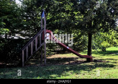 Abgenutzte Rutsche im Schatten in einem Park Stockfoto