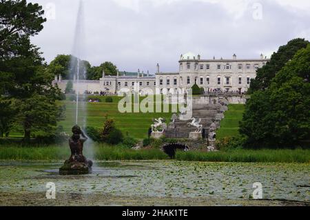 Enniskerry, Irland: Powerscourt Gardens, Blick auf den Triton Lake Brunnen und das Herrenhaus Stockfoto