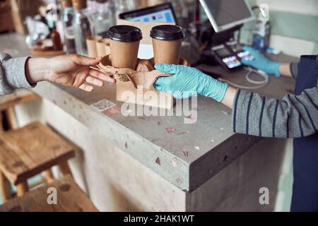 Asiatische weibliche Arbeitgeberin, die Kaffee im Café serviert Stockfoto