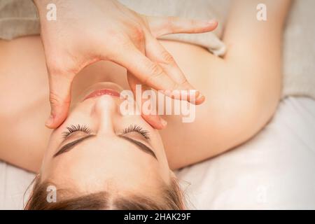 Gesichtsmassage mit den Fingern eines Masseurs. Weibliche Gesichtshautpflege in einem Schönheitssalon Stockfoto