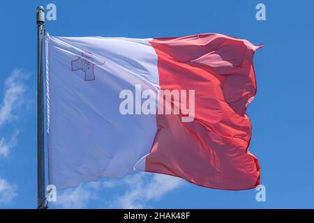 Maltesische Nationalflagge winkt auf blauem Himmel Hintergrund. Republik Malta, MT Stockfoto