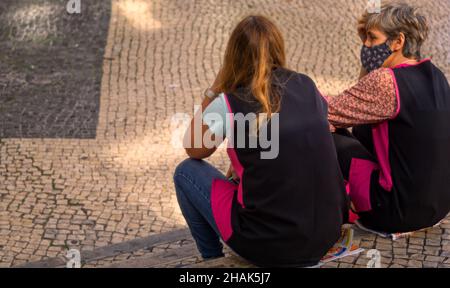 LISBOA, PORTUGAL - 25. Nov 2021: Lisboa, Portugal,19,2021. Oktober: Mortimer Moniz zwei müde Putzfrauen ruhten sich auf der Straße aus. Stockfoto