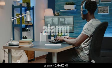 Mann, der als Videofilmer arbeitet, der Videomontage von Menschen bearbeitet, die am Computer tanzen, während er Kopfhörer verwendet. Medienredakteur, der Retuscharbeiten und visuelle Effekte auf Filmmaterial für die Filmproduktion macht Stockfoto