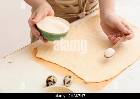 Frau bereitet Apfelstrudel am Tisch in der Küche vor Stockfoto