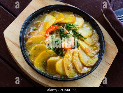 Spezialgericht der alten russischen Küche Skobjanka - Kartoffeln und Fleisch in Creme-Pilz-Sauce mit saisonalem Gemüse geschmort. Hochwertige Fotos Stockfoto