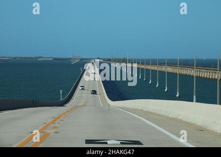 Auto, das die 7 Meilen lange Brücke hinunter fährt, mit den Florida Keys im Hintergrund und dem blauen Wasser des Golfs von Mexiko Stockfoto