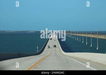 Auto, das die 7 Meilen lange Brücke hinunter fährt, mit den Florida Keys im Hintergrund und dem blauen Wasser des Golfs von Mexiko Stockfoto