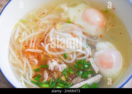 Suppenschüssel, Suppennudel Schweinefleisch weiße Nudel mit vietnamesischen Schweinefleisch weich gekochte Eier und Bohnensprossen Gemüsefrühlingszwiebel in Suppenschüssel auf Holztisch, Th Stockfoto