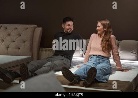 Fröhliches Paar, das im Geschäft neue Matratzen auswählt Stockfoto