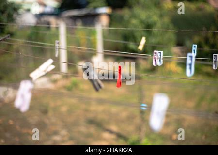 Nahaufnahme von bunten Plastikkleidernadeln am Seil vor einem verschwommenen Hintergrund Stockfoto