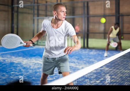 Konzentrierter Paddle-Tennisspieler, der sich auf die Vorhand vorbereitet Stockfoto