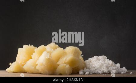 Gekochte Maniok oder Manihot mit Kokosraspeln, auch bekannt als Maniok, Yuca oder brazillianische Pfeilwurzel mit geriebener Kokosnuss, vegetarisches Gericht Stockfoto