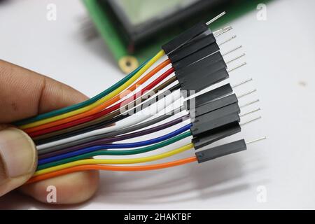 Steckverbinderstecker mit Überbrückungskabeln. Kabel, die in Projekten der Entwicklungsplatine zum Herstellen von Verbindungen zwischen elektronischen Komponenten verwendet werden Stockfoto