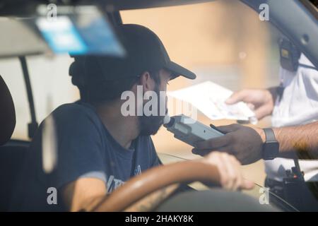 Highway 2 Bukarest - Constanta, Rumänien - 10. August 2021: Rumänischer Polizeibeamter übergibt einem Fahrer einen Alkoholtester, um seinen Alkoholgehalt zu testen. Stockfoto