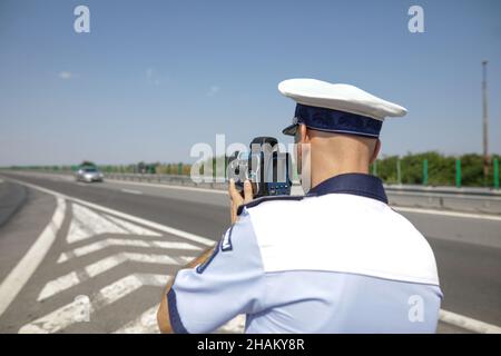 Highway 2 Bukarest - Constanta, Rumänien - 10. August 2021: Der rumänische Verkehrspolizisten verwendet ein Radargewehr. Stockfoto