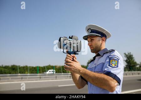 Highway 2 Bukarest - Constanta, Rumänien - 10. August 2021: Der rumänische Verkehrspolizisten verwendet ein Radargewehr. Stockfoto