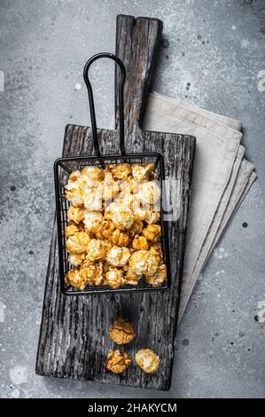 Popcorn mit Karamell im Korb. Grauer Hintergrund. Draufsicht Stockfoto