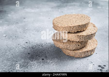 Rohe fleischfreie Burger-Patties auf pflanzlicher Basis, vegetarische Koteletts. Grauer Hintergrund. Draufsicht. Speicherplatz kopieren Stockfoto