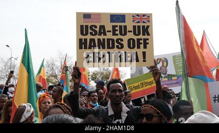 Jerusalem, Israel. 13h Dez 2021. Ein Protestierender hält ein Plakat mit der Aufschrift „USA EU UK Hände weg von Eritrea“ während eines Protestes von äthiopischen Juden und Mitgliedern der eritreischen Migrantengemeinschaft gegen die Politik der Vereinigten Staaten gegenüber dem Tigray-Konflikt in Äthiopien vor der US-Botschaft am 13. Dezember 2021 in Jerusalem, Israel. Kredit: Eddie Gerald/Alamy Live Nachrichten Stockfoto