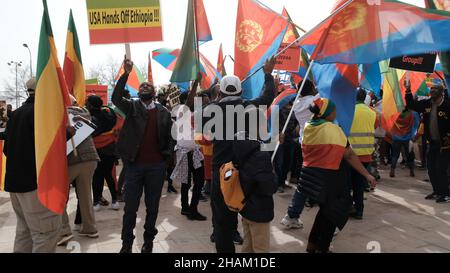 Jerusalem, Israel. 13h Dez 2021. Äthiopische Juden und Mitglieder der eritreischen Migrantengemeinschaft in Israel halten Plakate und Flaggen von Äthiopien und Eritrea, während sie während eines Protestes gegen die Politik der Vereinigten Staaten gegen den Tigray-Konflikt in Äthiopien am 13. Dezember 2021 vor der US-Botschaft in Jerusalem, Israel, tanzen. Kredit: Eddie Gerald/Alamy Live Nachrichten Stockfoto