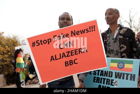 Jerusalem, Israel. 13h Dez 2021. Ein Protestor hält ein Plakat mit der Aufschrift „Stop Fake News! CNN ALJAZEERA BBC' während eines Protestes von äthiopischen Juden und Mitgliedern der eritreischen Migrantengemeinschaft gegen die Politik der Vereinigten Staaten gegenüber dem Tigray-Konflikt in Äthiopien vor der US-Botschaft am 13. Dezember 2021 in Jerusalem, Israel. Kredit: Eddie Gerald/Alamy Live Nachrichten Stockfoto