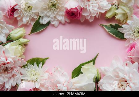 Rahmen aus Blumen auf pastellrosa Hintergrund. Stockfoto