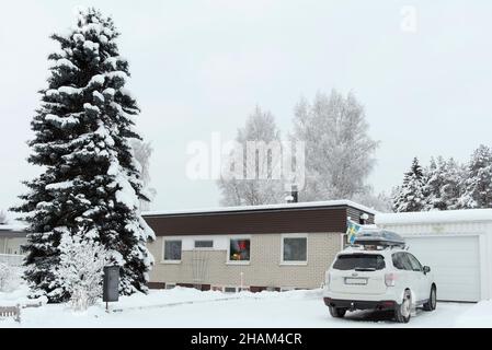 UMEA, SCHWEDEN AM 08. DEZEMBER 2021. Bedecktes Anwesen im neu gefallenen Schnee. Verschneite Auffahrt, Haus und Garten. Weihnachten. Redaktionell. Stockfoto