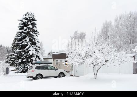 UMEA, SCHWEDEN AM 08. DEZEMBER 2021. Bedecktes Anwesen im neu gefallenen Schnee. Verschneite Auffahrt, Haus und Garten. Weihnachten. Redaktionell. Stockfoto