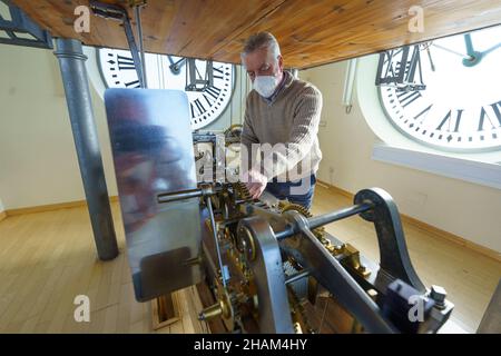 Madrid, Spanien. 13th Dez 2021. Der Uhrmacher der Puerta del Sol, Jesus Lopez-Terradas, posiert mit einer Uhr, die bereit ist, am 31. Dezember in der Puerta del Sol.Madrid Glockenspiele zu geben.die letzten Vorbereitungen, um in 18 Tagen das mythische Glockenspiel des Endes des Jahres zu feiern. Die Uhr, die 1866 in London hergestellt wurde, zählt die 12 Sekunden vor Mitternacht am 31. Dezember, um das neue Jahr 2022 einzuläuten. Kredit: SOPA Images Limited/Alamy Live Nachrichten Stockfoto